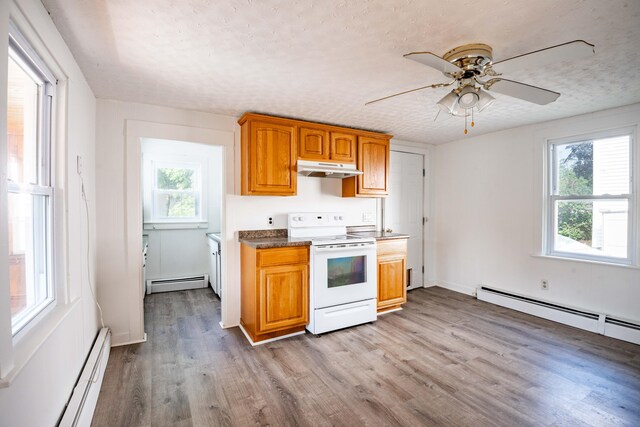 19 Fall St, Biddeford, ME 04005 - kitchen featuring electric stove, baseboard heating, under cabinet range hood, plenty of natural light, and a textured ceiling