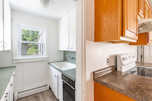 19 Fall St, Biddeford, ME 04005 - kitchen featuring a baseboard radiator, wood finished floors, under cabinet range hood, white range with electric cooktop, and black dishwasher