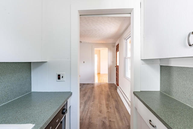 19 Fall St, Biddeford, ME 04005 - hallway with a baseboard heating unit and wood finished floors