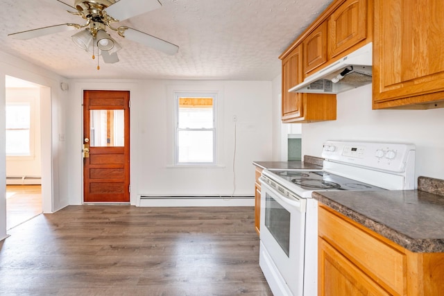 19 Fall St, Biddeford, ME 04005 - kitchen featuring white electric range oven, under cabinet range hood, a baseboard radiator, dark countertops, and a textured ceiling