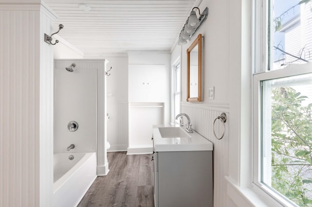 19 Fall St, Biddeford, ME 04005 - bathroom featuring healthy amount of natural light, vanity, a wainscoted wall, wood finished floors, and bathtub / shower combination