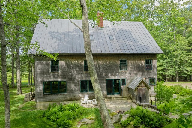 372 Bald Head Rd, Arrowsic, ME 04530 - back of house featuring a patio, a chimney, a standing seam roof, and a metal roof