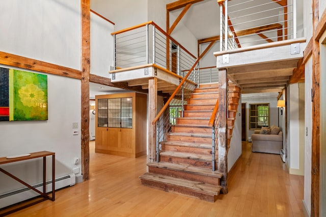 372 Bald Head Rd, Arrowsic, ME 04530 - stairway featuring baseboard heating, wood finished floors, and a high ceiling