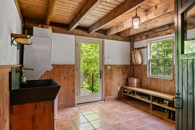 372 Bald Head Rd, Arrowsic, ME 04530 - mudroom with wood walls, plenty of natural light, a wainscoted wall, light tile patterned flooring, and a wooden ceiling with exposed beams