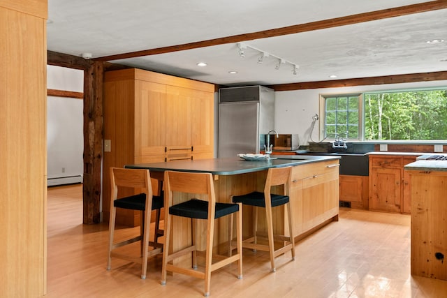 372 Bald Head Rd, Arrowsic, ME 04530 - kitchen featuring high quality fridge, a baseboard heating unit, track lighting, light wood-style flooring, and a center island with sink