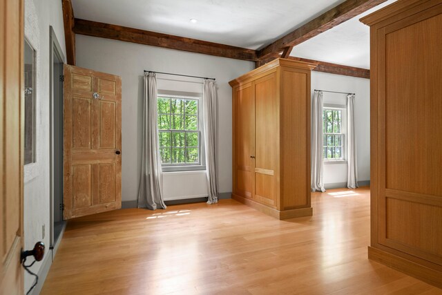 372 Bald Head Rd, Arrowsic, ME 04530 - unfurnished bedroom with multiple windows, beamed ceiling, and light wood-style floors