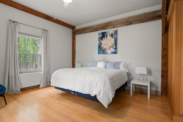 372 Bald Head Rd, Arrowsic, ME 04530 - bedroom with light wood-style floors, beam ceiling, radiator heating unit, and a ceiling fan