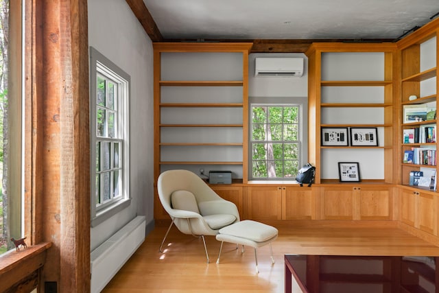372 Bald Head Rd, Arrowsic, ME 04530 - sitting room with a wall unit AC, wood finished floors, and plenty of natural light