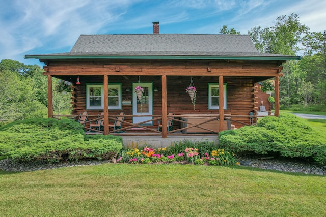 15 Tranquility Way, Ellsworth, ME 04605 - log-style house featuring log siding, covered porch, a front lawn, and a chimney