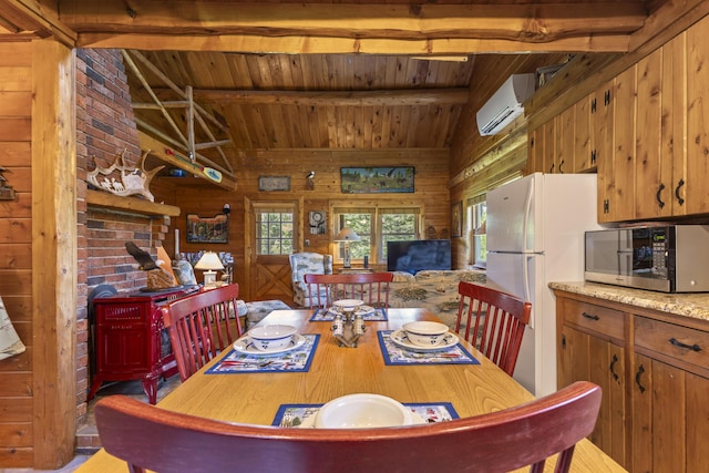 15 Tranquility Way, Ellsworth, ME 04605 - dining area featuring a wall mounted AC, wooden ceiling, wood walls, and a wood stove