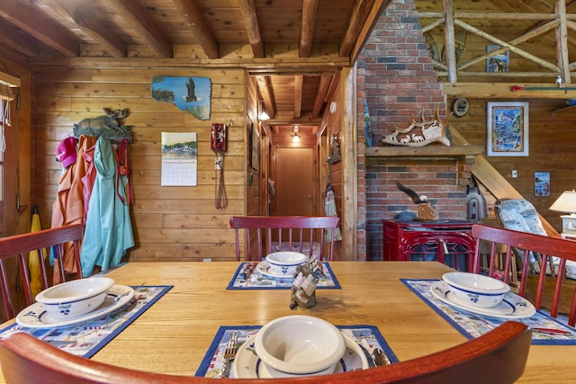 15 Tranquility Way, Ellsworth, ME 04605 - dining room featuring a wood ceiling with exposed beams, wooden walls, and a wood stove