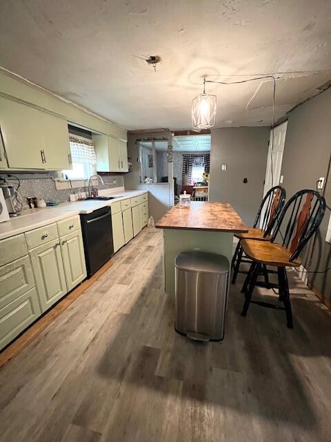 20 Coles Corner Rd, Winterport, ME 04496 - kitchen with black dishwasher, light wood-style flooring, a kitchen island, tasteful backsplash, and pendant lighting