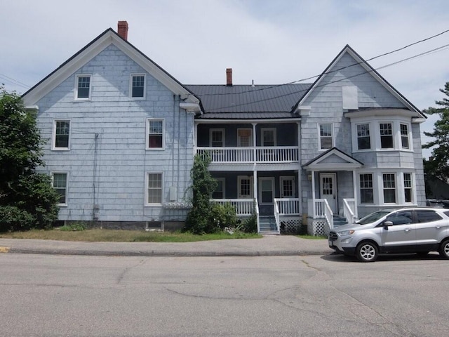 175 Alfred St, Biddeford, ME 04005 - townhome / multi-family property featuring a chimney, a porch, a balcony, a standing seam roof, and a metal roof