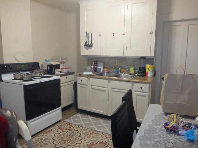 175 Alfred St, Biddeford, ME 04005 - kitchen featuring white electric stove, white cabinets, tasteful backsplash, and light countertops