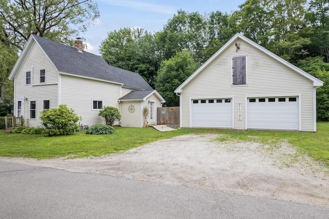 23 Cottage Dr, Friendship, ME 04547 - view of front of property featuring a chimney, a shingled roof, an outbuilding, a front lawn, and a detached garage