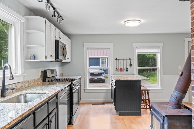 23 Cottage Dr, Friendship, ME 04547 - kitchen with open shelves, stainless steel appliances, plenty of natural light, light wood-style floors, and wainscoting