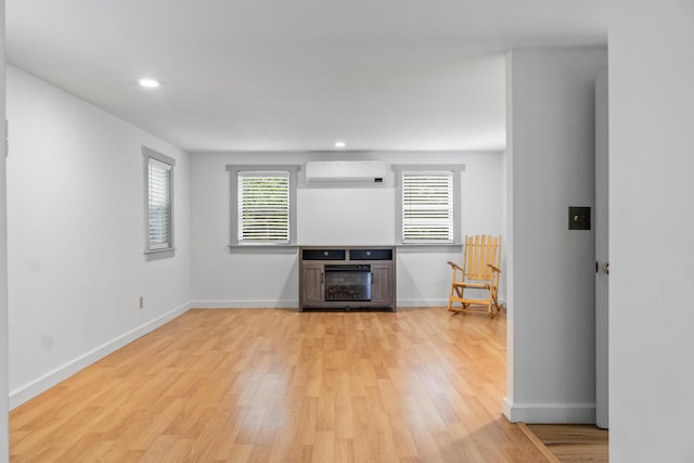 23 Cottage Dr, Friendship, ME 04547 - unfurnished living room featuring an AC wall unit, light wood-type flooring, healthy amount of natural light, recessed lighting, and a fireplace