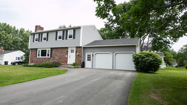 48 Clover Ln, Brewer, ME 04412 - colonial inspired home featuring an attached garage, a chimney, driveway, a front yard, and brick siding
