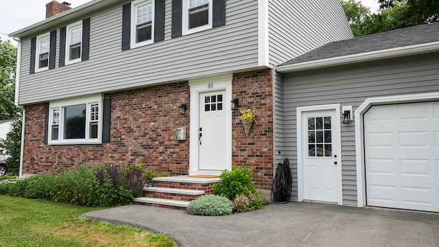 48 Clover Ln, Brewer, ME 04412 - view of front of property with brick siding, a chimney, and an attached garage