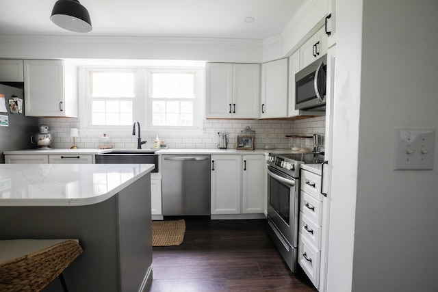 48 Clover Ln, Brewer, ME 04412 - kitchen with appliances with stainless steel finishes, crown molding, tasteful backsplash, and white cabinetry