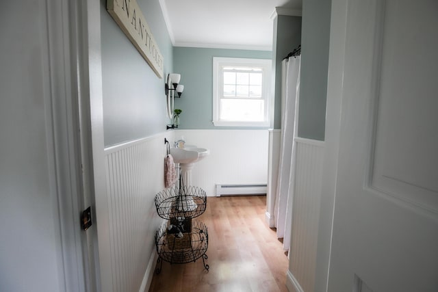 48 Clover Ln, Brewer, ME 04412 - corridor featuring a baseboard heating unit, crown molding, a wainscoted wall, and light wood-type flooring