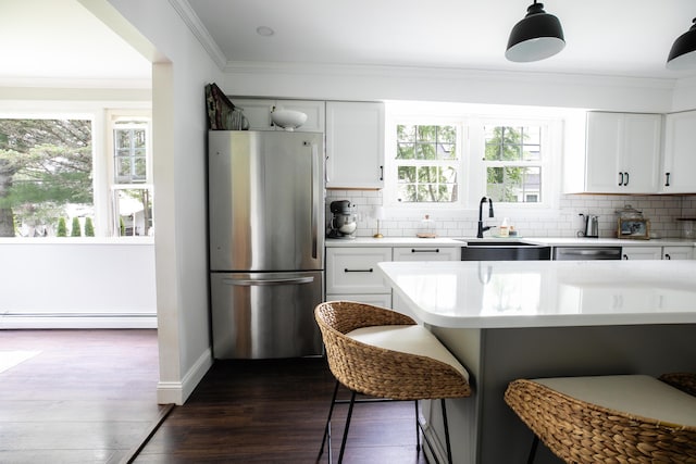 48 Clover Ln, Brewer, ME 04412 - kitchen featuring appliances with stainless steel finishes, a baseboard radiator, light countertops, decorative backsplash, and ornamental molding