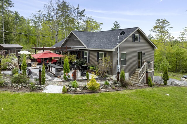 85 Lions Ridge Rd, Alna, ME 04535 - back of property with a patio area, a shingled roof, and a lawn