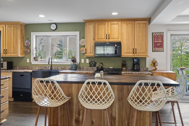 85 Lions Ridge Rd, Alna, ME 04535 - kitchen with black appliances, a breakfast bar, wood finished floors, recessed lighting, and a center island