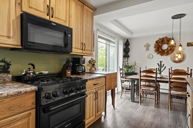 85 Lions Ridge Rd, Alna, ME 04535 - kitchen with black appliances, wood finished floors, a tray ceiling, decorative light fixtures, and stone countertops