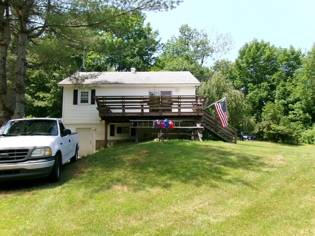 76 Gile Rd, Fayette, ME 04349 - rear view of property featuring a wooden deck, a lawn, stairs, and a garage