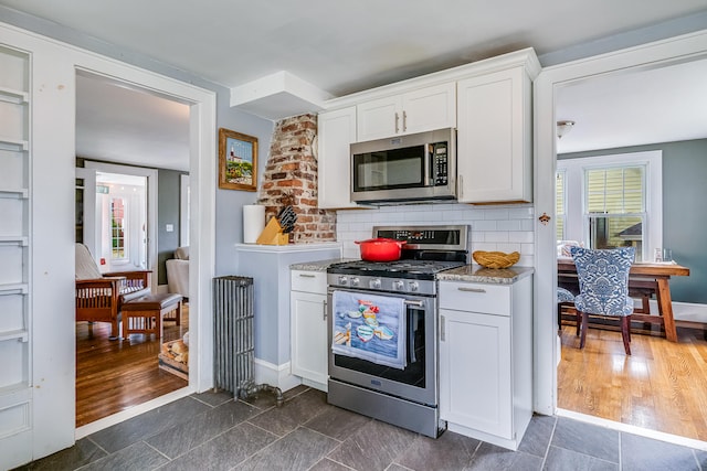 46 Haven Rd, South Portland, ME 04106 - kitchen with stainless steel appliances, white cabinetry, plenty of natural light, and light stone counters