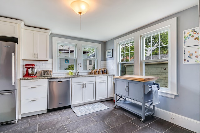 46 Haven Rd, South Portland, ME 04106 - kitchen featuring stainless steel appliances, white cabinetry, decorative backsplash, and light stone counters