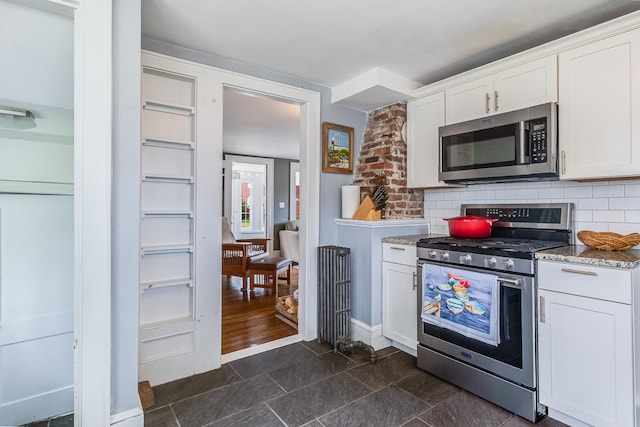 46 Haven Rd, South Portland, ME 04106 - kitchen featuring appliances with stainless steel finishes, white cabinetry, tasteful backsplash, and light stone counters