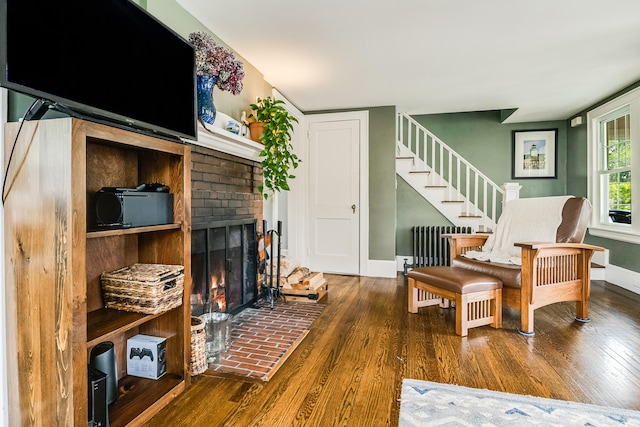 46 Haven Rd, South Portland, ME 04106 - living room featuring radiator, wood finished floors, a fireplace, and stairway