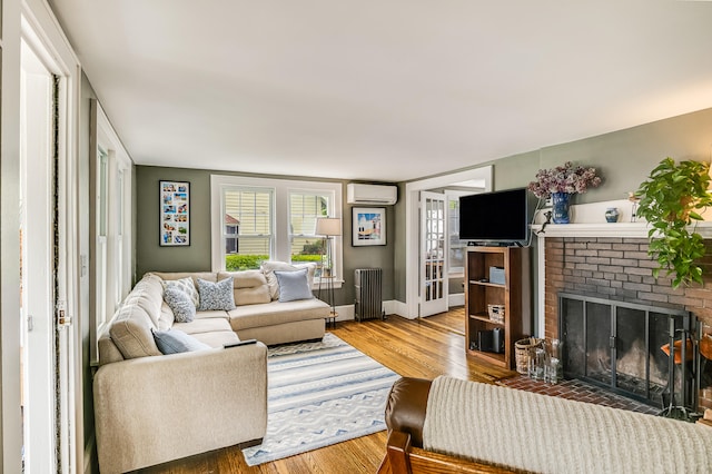 46 Haven Rd, South Portland, ME 04106 - living area featuring radiator, an AC wall unit, wood finished floors, and a brick fireplace