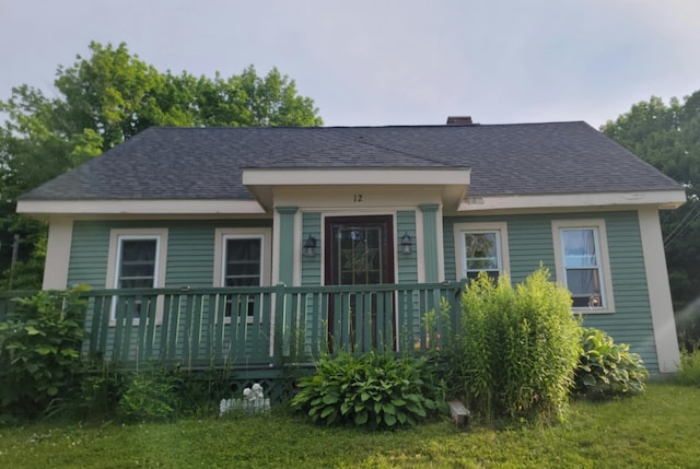 12 High St, Calais, ME 04619 - view of front of house with roof with shingles, a deck, a chimney, and a front yard