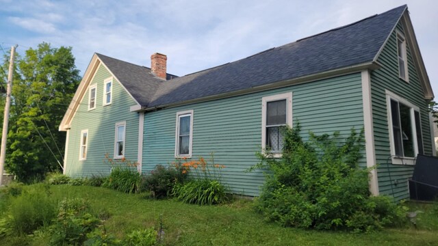 12 High St, Calais, ME 04619 - view of home's exterior featuring a chimney and roof with shingles
