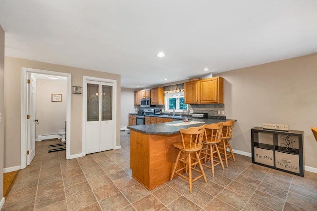 125 Deer Ridge Dr, Barrington, NH 03825 - kitchen with appliances with stainless steel finishes, dark countertops, a peninsula, recessed lighting, and baseboard heating