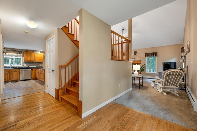 125 Deer Ridge Dr, Barrington, NH 03825 - stairs with plenty of natural light, wood finished floors, and a baseboard radiator