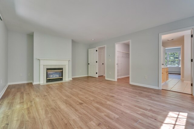 8 Woodside Dr Unit 1, Gorham, ME 04038 - unfurnished living room with light wood-style flooring, a fireplace, and a baseboard heating unit