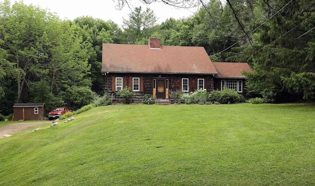 32 Williams Rd, Chelsea, ME 04330 - cape cod-style house featuring a chimney, a front yard, and a storage shed