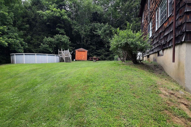 32 Williams Rd, Chelsea, ME 04330 - view of grassy yard with a storage unit, an outdoor pool, and a view of trees