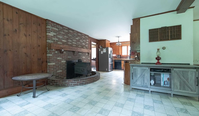 32 Williams Rd, Chelsea, ME 04330 - living room featuring light floors, wooden walls, and a wood stove