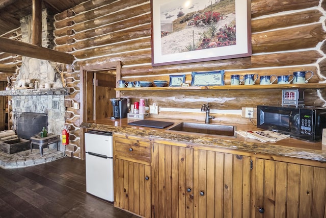 1 Zella Is Unit T14 R8, Wels, ME 04768 - kitchen with white fridge, black microwave, log walls, dark wood-style flooring, and brown cabinets