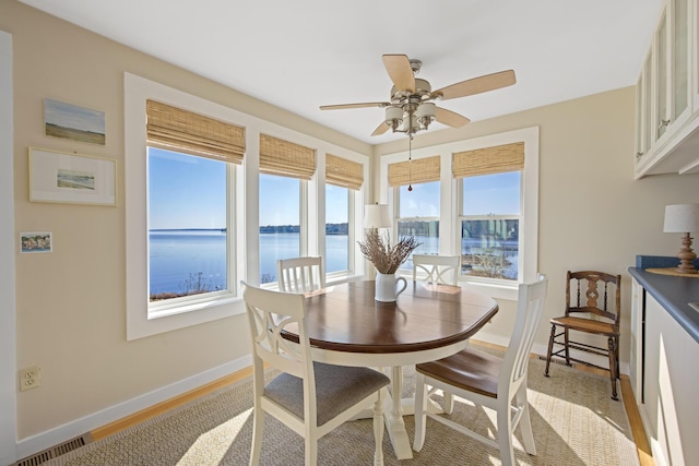 74 Spindle Rd, Ellsworth, ME 04605 - dining room featuring a water view, ceiling fan, and light wood-style flooring