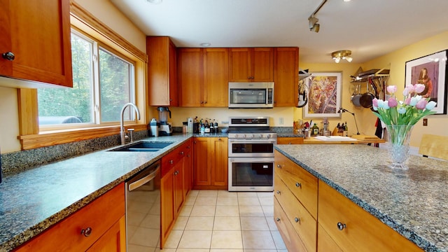 93 Hopkins Rd, Hampden, ME 04444 - kitchen with stainless steel appliances, light tile patterned flooring, brown cabinets, and dark stone countertops
