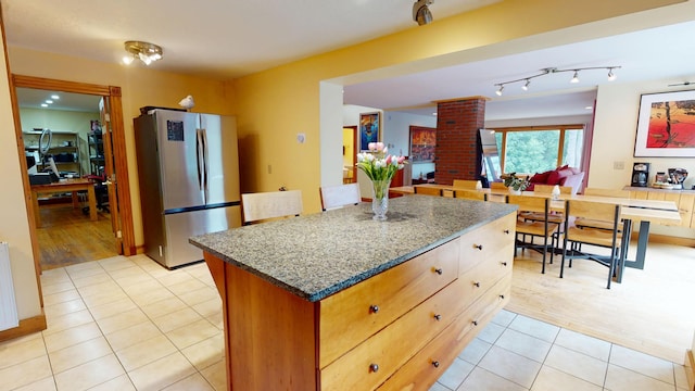 93 Hopkins Rd, Hampden, ME 04444 - kitchen featuring freestanding refrigerator, light tile patterned floors, a center island, dark stone countertops, and rail lighting