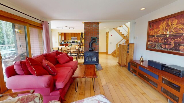 93 Hopkins Rd, Hampden, ME 04444 - living room featuring a wood stove, stairs, and wood-type flooring