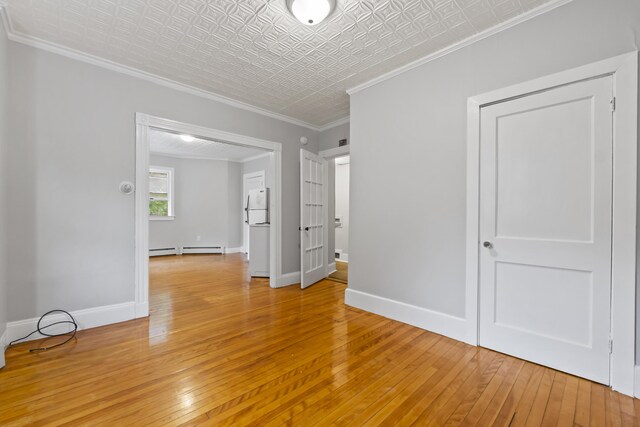 13 Newman St, Lewiston, ME 04240 - spare room with light wood finished floors, a baseboard radiator, an ornate ceiling, and crown molding