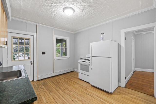 13 Newman St, Lewiston, ME 04240 - kitchen with white appliances, baseboard heating, ornamental molding, light wood finished floors, and dark countertops